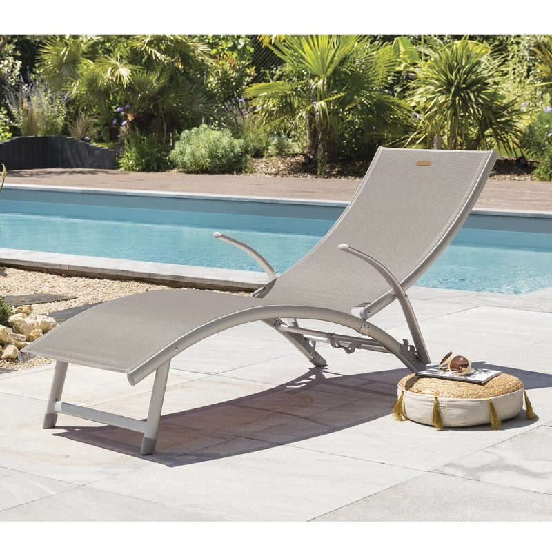 Transat Samba pliable et empilable taupe Hespéride dans un jardin contemporain